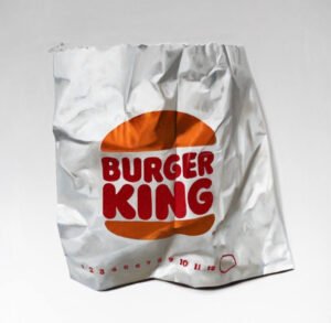 A crumpled Burger King bag painted in oil by Gennaro Santaniello, highlighting urban consumerism and artistic storytelling.