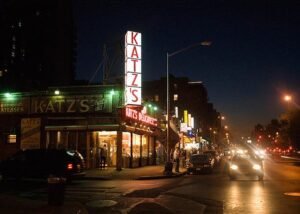 Katz’s Delicatessen storefront on the Lower East Side with a line of customers waiting for iconic pastrami sandwiches