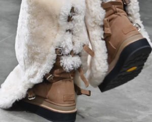 Model wearing Sacai’s Fall/Winter 2025 oversized coat and UGG boots, showcasing deconstructed luxe and bold winter styles