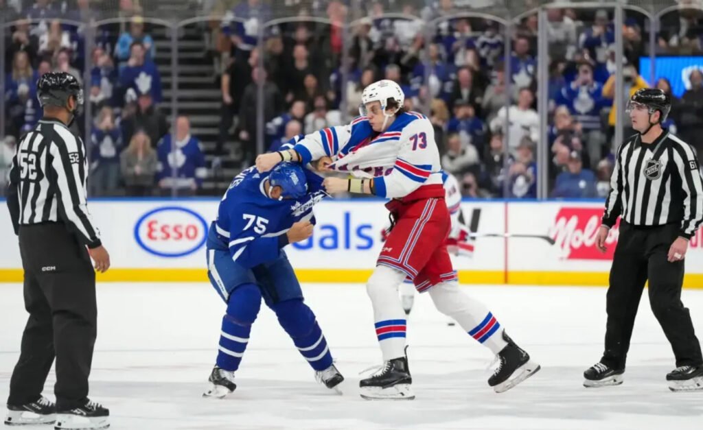 Ryan Reaves and Mathieu Olivier drop the gloves in a heated NHL fight, exchanging powerful punches at center ice