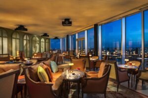 A luxurious room at TOO Hotel Paris, showcasing floor-to-ceiling windows with breathtaking Eiffel Tower and city skyline views