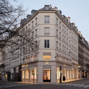 AMI Paris flagship store featuring elegant interiors with Euville stone, warm wood accents, and a sustainable fashion program