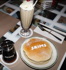 Exterior of the SKIMS diner activation at Mel’s Drive-In, styled in pink with branded uniforms and curated experience zones