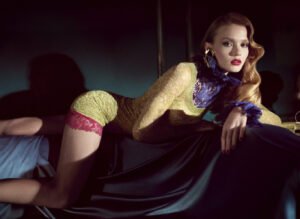 Model in Saint Laurent Summer 2025 collection standing in soft light against a minimalist concrete backdrop