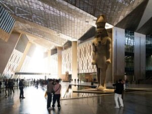 Visitors walk through the atrium of the partially opened Global Museum of Art and Ideas, surrounded by modern architecture