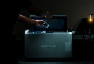 EcoFlow Glacier Classic portable refrigerator placed outdoors on a campsite, powered by a solar panel under daylight