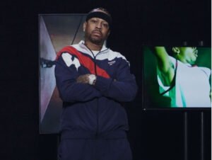 Jide Osifeso standing in Reebok studio surrounded by mood boards and sneakers, signaling new basketball vision for the brand