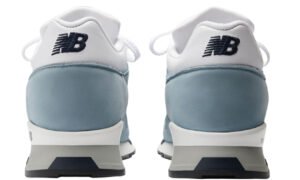 Close-up of New Balance 1500 “Iconic Influences” sneaker in grey suede and mesh, photographed on urban pavement