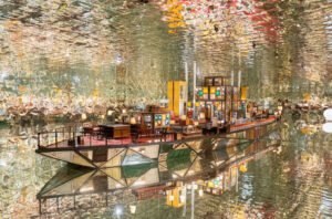 Song Dong’s A Quarter installation at Ennova Art Museum featuring mirrored surfaces, collected furniture, and warm lighting