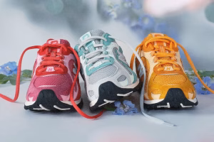 Kith x New Balance 204L shoe in beige suede with floral embroidery on heel and midfoot, placed on stone steps