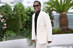 photo of A$ap Rocky, white tailor suit, in mid walk, tropical background scenery