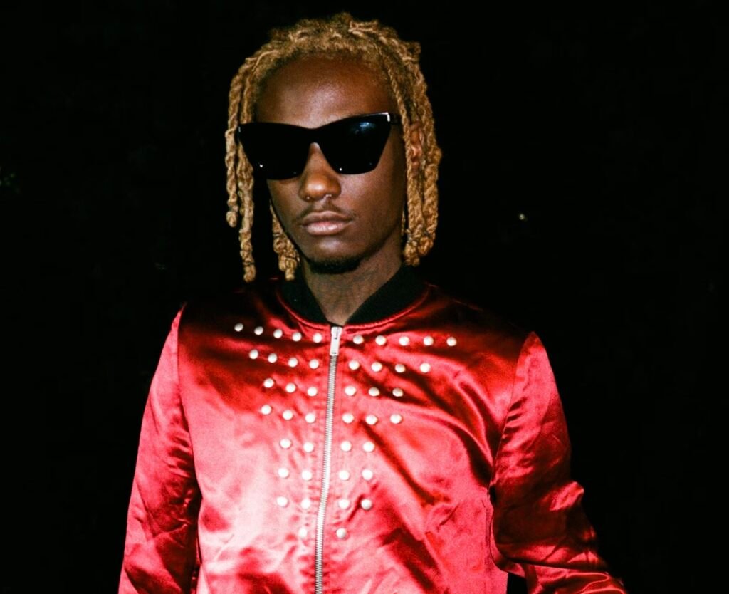 image of OsamaSon, wearing a red slim jacket with studded upon the front