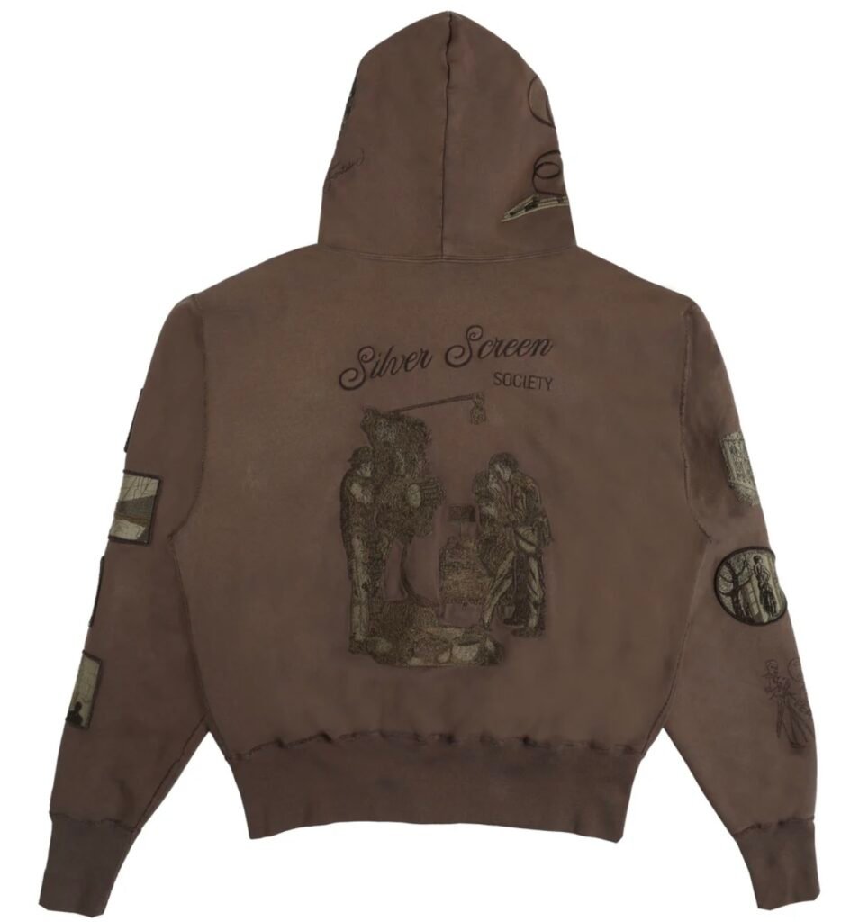 Back view of brown zip hoodie featuring embroidered “Silver Screen Society” lettering and a detailed scene of a vintage film crew operating a camera, evoking classic cinema aesthetics.