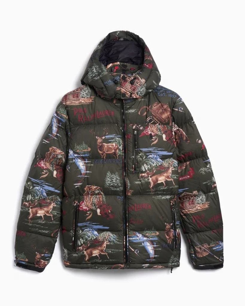Studio photo of the Polo Ralph Lauren Gorham Sportsman Ripstop Graphic Men’s Down Jacket in navy blue. The jacket features a matte ripstop nylon shell, down-filled quilting, and bold Polo Sportsman graphics printed across the back and sleeves. Shown against a plain white background, highlighting its rugged construction and vintage outdoor-inspired design.