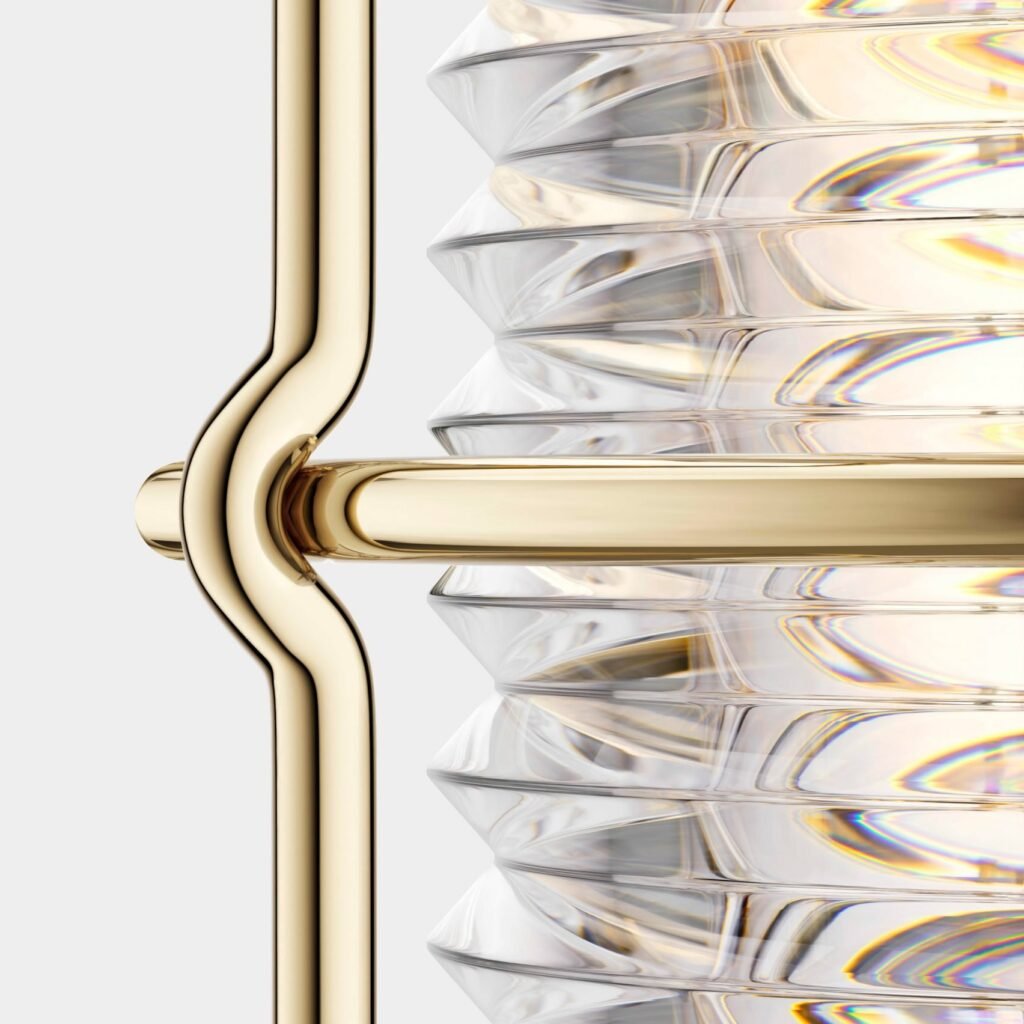 Detailed macro view of the Balmuda “Sailing Lantern” showing the curved gold-toned brass frame and ribbed glass housing that refracts warm light through its precision-cut surface.