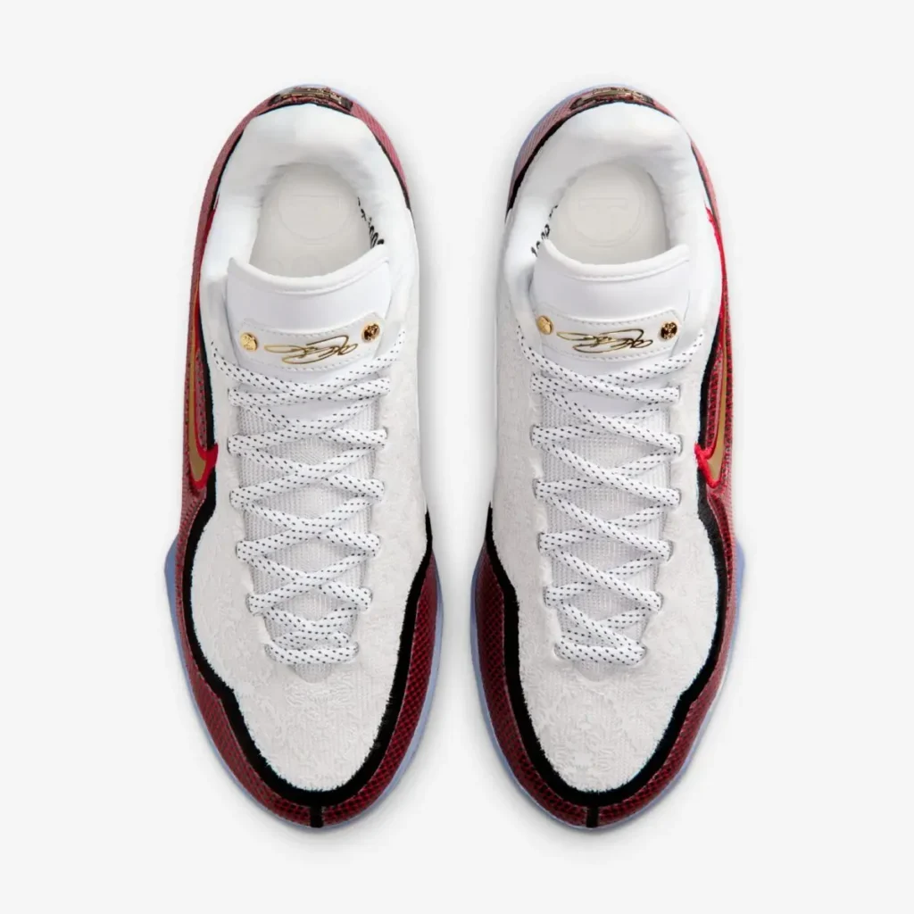 Rear view of the Nike LeBron 23 “Grand Opening” sneakers displaying red mesh heel panels with black trim, metallic gold “LJ” crown logos, and icy blue translucent outsoles extending upward along the heel.