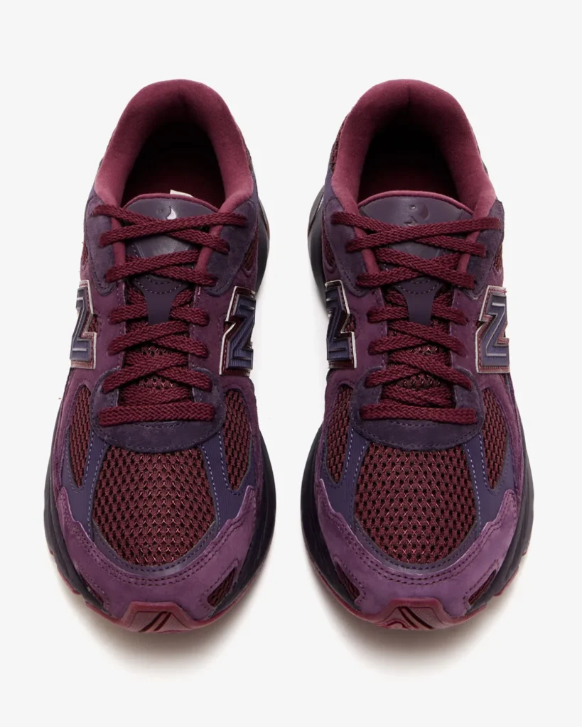 Top-down view of the Rich Paul x New Balance 2010 sneakers in plum-brown and burgundy tones, featuring mesh uppers, suede overlays, rope laces, and embossed “R” branding on the tongues, emphasizing the shoe’s balanced luxury and performance design