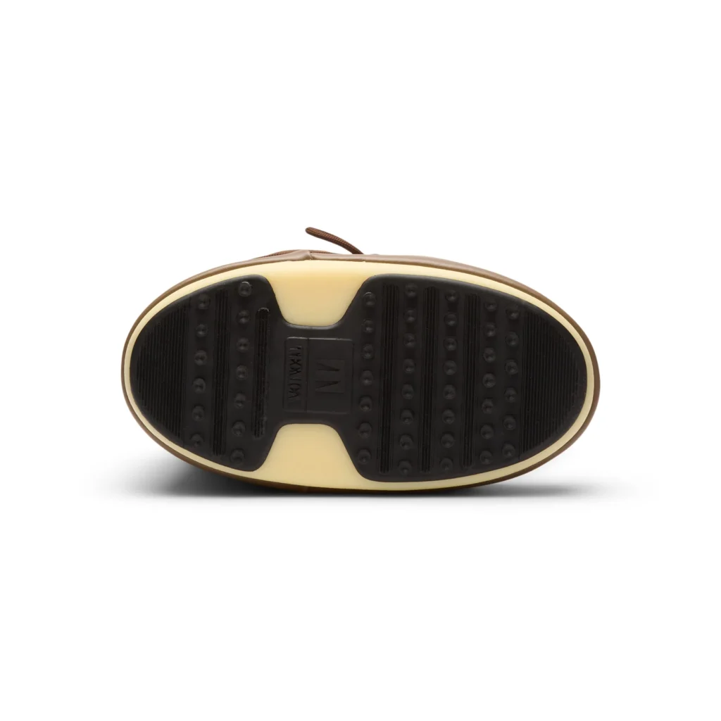 Bottom view of the brown Tecnica Moon Boot Icon Nylon Boot showing the black rubber outsole with textured grip ridges, raised traction dots, and a central Tecnica logo panel