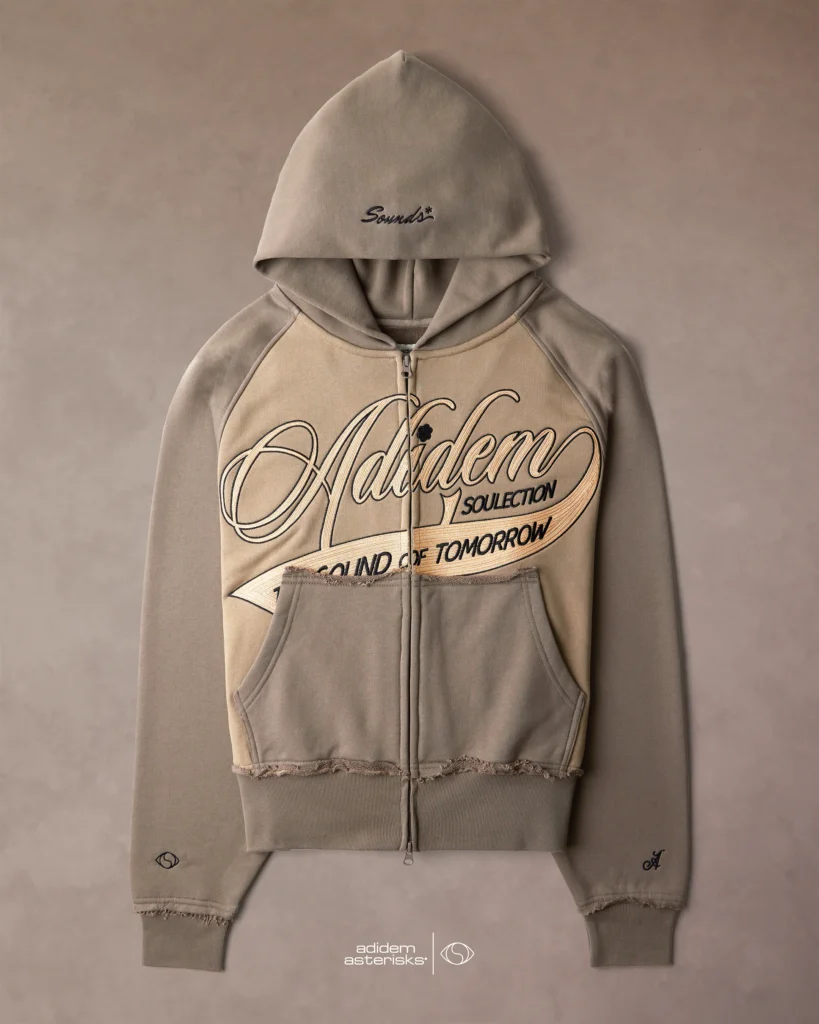 Taupe Adidem Asterisks zip-up hoodie with oversized cursive chainstitch logo reading “Adidem Soulection – The Sound of Tomorrow,” featuring raglan sleeves, distressed hems, front pouch pockets, and “Sounds” embroidery on the hood