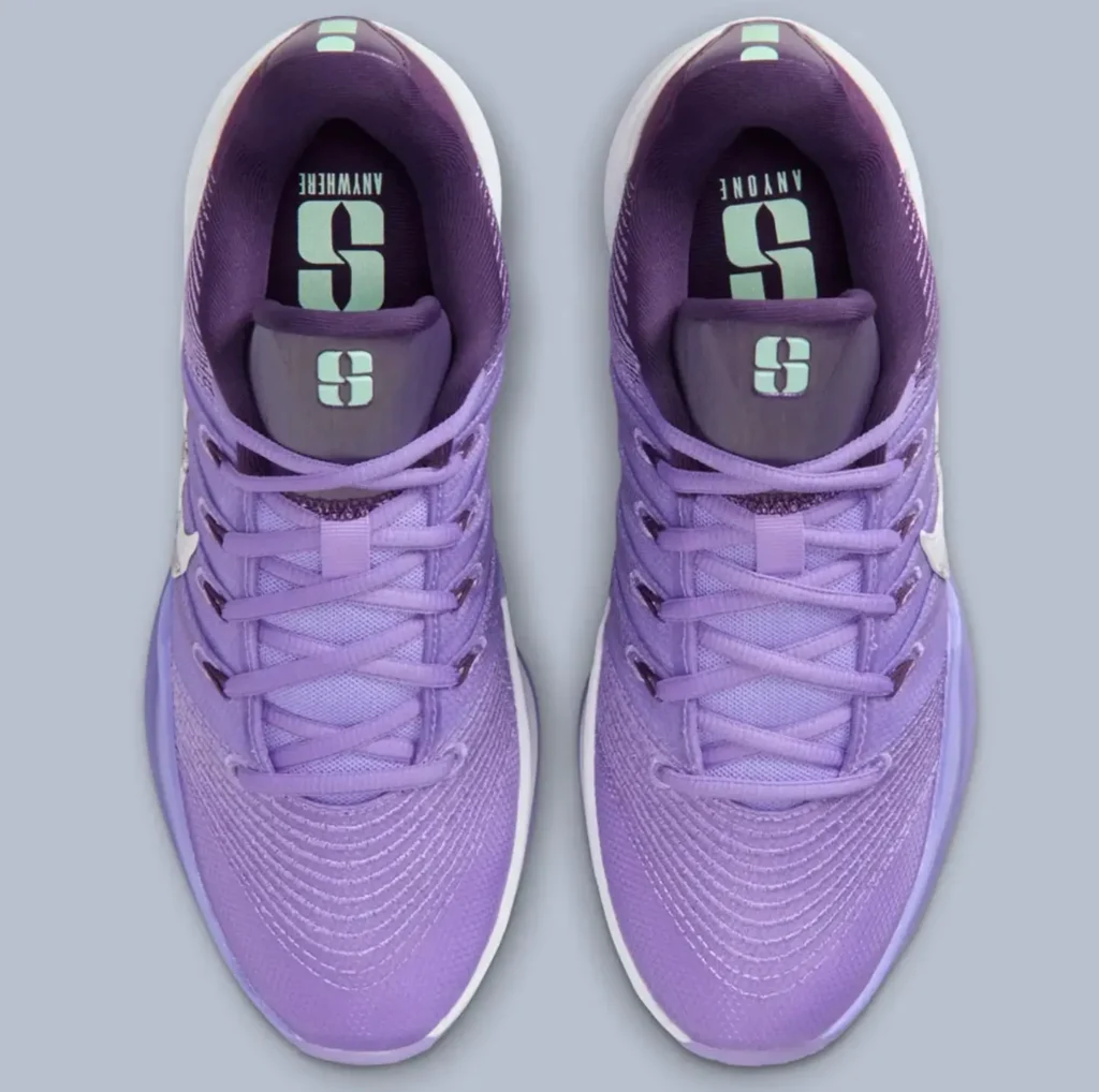 Top-down view of the Nike Sabrina 3 “Flowers” showcasing the lavender mesh upper, symmetrical lacing system, mint-green “S” logo on the tongues and insoles, and gradient purple detailing against a soft grey background