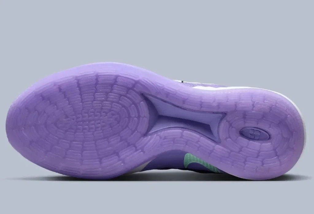 Bottom view of the Nike Sabrina 3 “Flowers” showing a translucent lavender outsole with a radial traction pattern, midfoot shank support, and sculpted grooves designed for multidirectional grip, set against a soft grey background