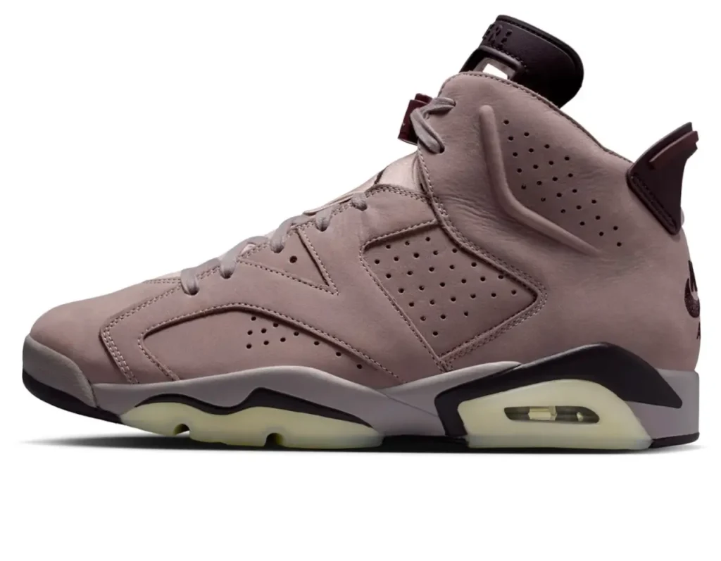 Side profile of the Air Jordan 6 × A Ma Maniére “Smokey Mauve,” showcasing the muted mauve suede upper, perforated panels, dark plum heel accents, and a translucent cream outsole with visible Air cushioning
