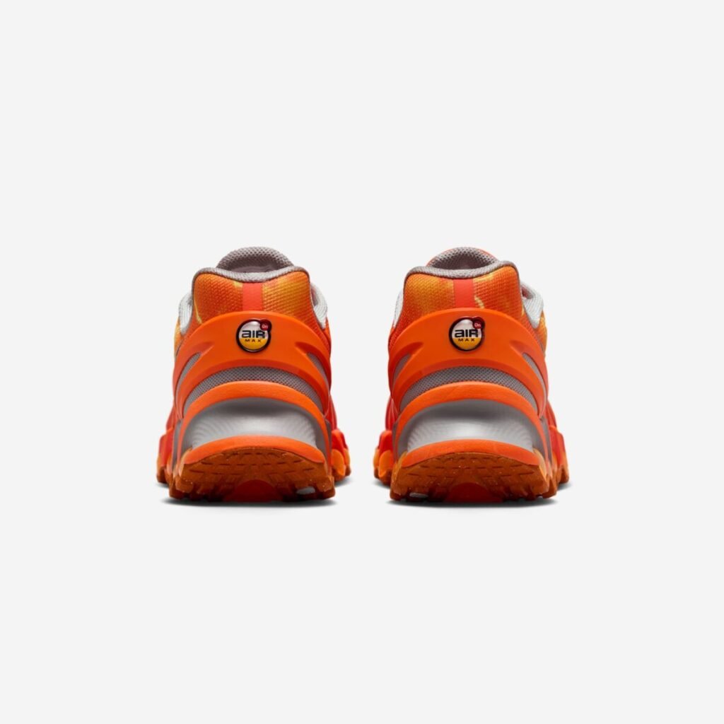 Rear view of the Palace x Nike Air Max DN8 “Safety Orange” sneakers, showing the bright orange heel structure with AIR MAX branding, grey mesh padding, layered midsole, and translucent DN8 Air pods along the outsole on a white background