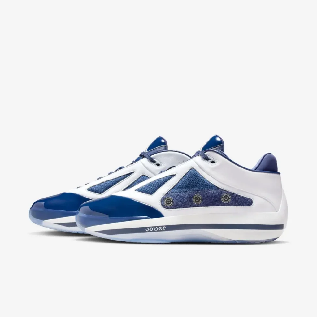 Air Jordan 4016 “Midnight Navy” sneakers shown in a side profile with the shroud removed, featuring a white leather upper, midnight navy mesh panels, glossy navy patent leather toe, metallic eyelet details along the midfoot, and a white midsole with navy Jordan branding on a clean white background
