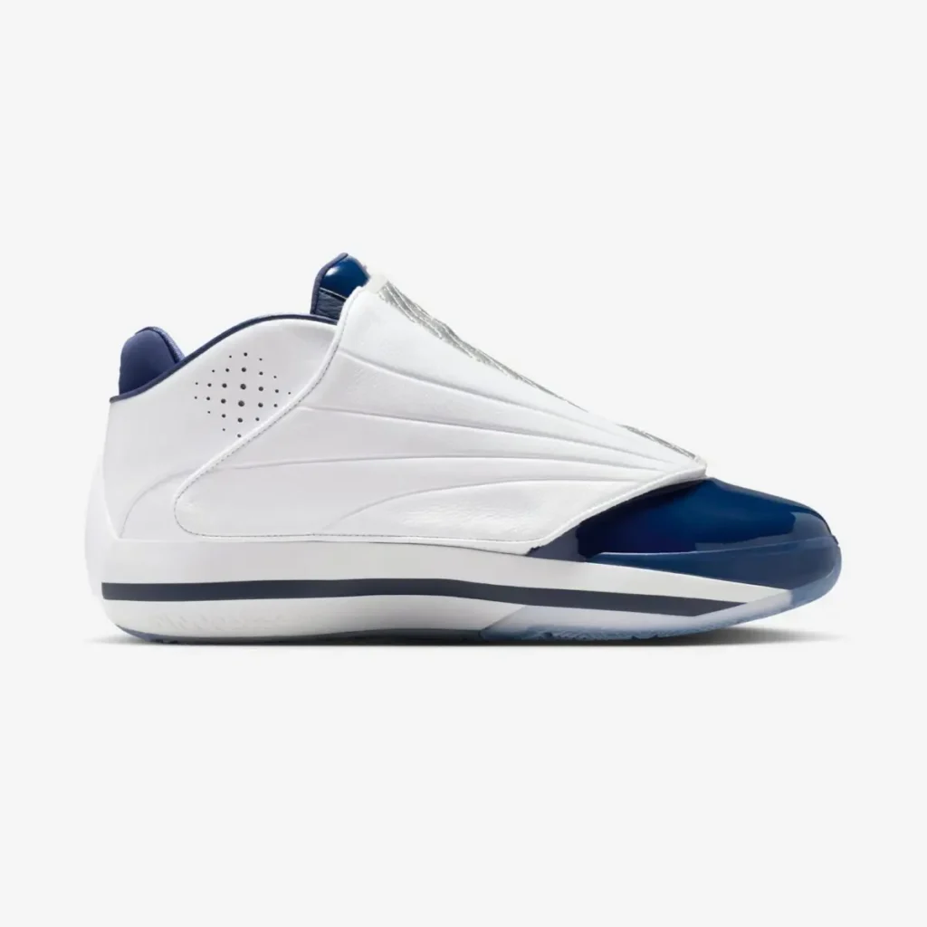 Air Jordan 4016 “Midnight Navy” shown in a lateral side view with the quilted shroud fastened, featuring a smooth white leather upper, sculpted paneling, glossy midnight navy patent leather toe cap, navy collar lining, and a white midsole with a dark accent stripe on a clean white background