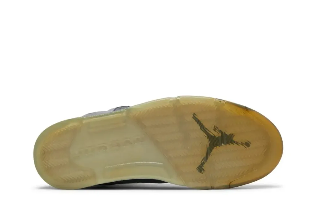Outsole view of the Air Jordan 5 “Wolf Grey,” featuring a translucent icy rubber sole with visible Jumpman logo and subtle yellowed tint from wear or aging