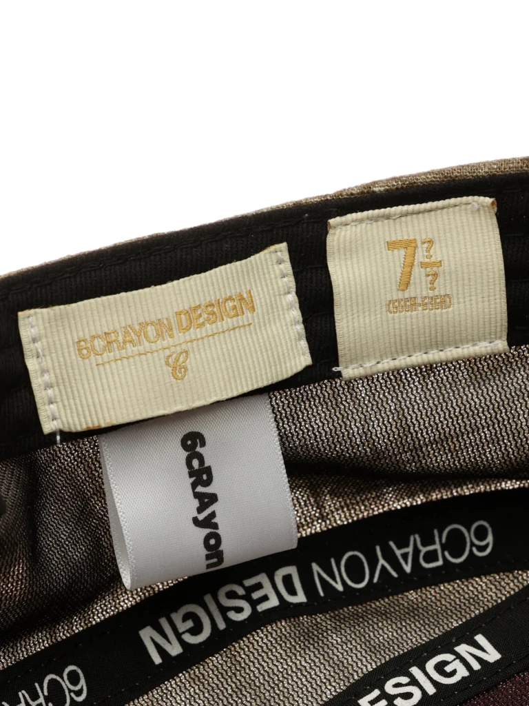 Angled inside rear view of the 6CRAYON Vintage Patchwork Flat Top Baseball Cap, highlighting the textured patchwork fabric in earthy tones, flat crown construction, and adjustable tan strap closure on a clean white background