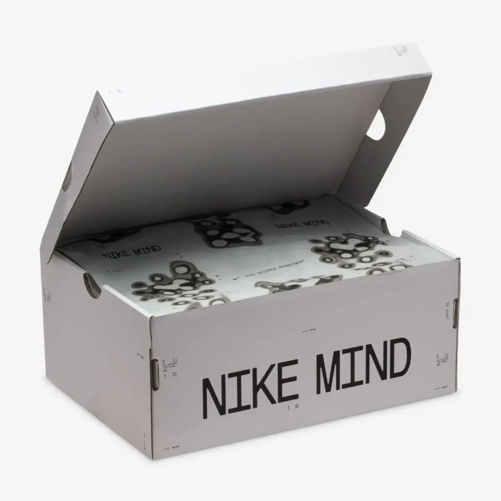 Nike Mind shoe box shown open, featuring minimalist grey packaging with “NIKE MIND” branding and printed interior graphics