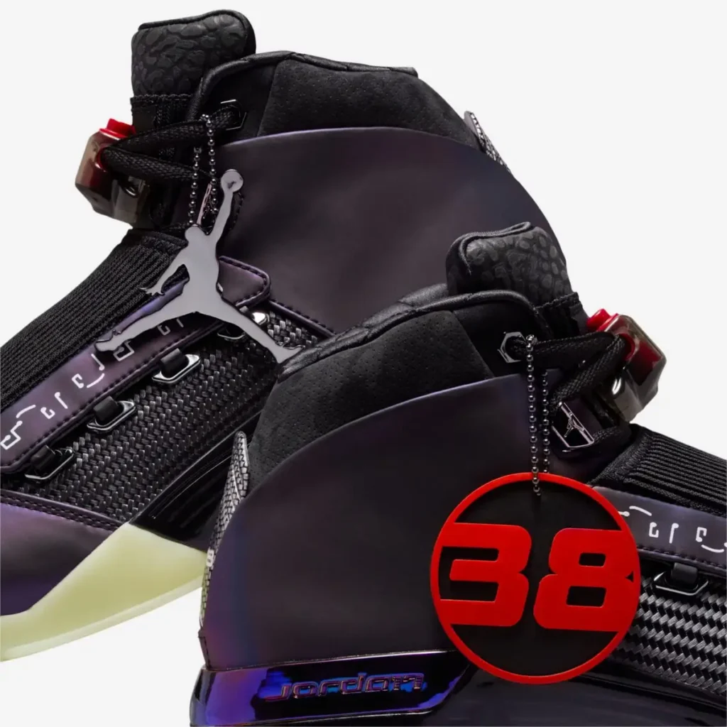 Close-up rear view of Zach Rumbaugh’s Air Jordan 17 “Doernbecher Freestyle,” highlighting the deep purple color-shifting heel panel, black padded collar, Jumpman hangtag, carbon-fiber-style midfoot detail, and a red circular “38” emblem referencing the Doernbecher story