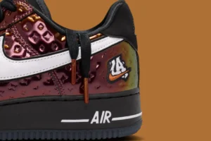 Nike Air Force 1 Low PRM “LA All-Star” sneaker close-up featuring iridescent embossed leather upper, white Swoosh, black midsole with AIR branding, copper lace tips, and “LA 24” embroidered patch detail