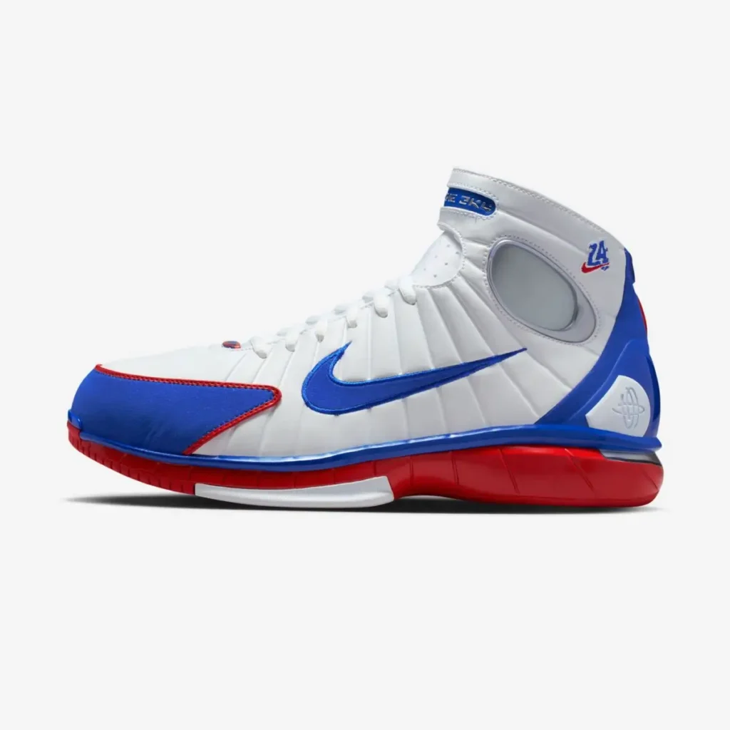 Side profile of the Nike Air Zoom Huarache 2K4 “All-Star” basketball shoe in a white, blue, and red colorway, featuring a high-top silhouette, large blue Swoosh, and red cushioned midsole against a clean gray background