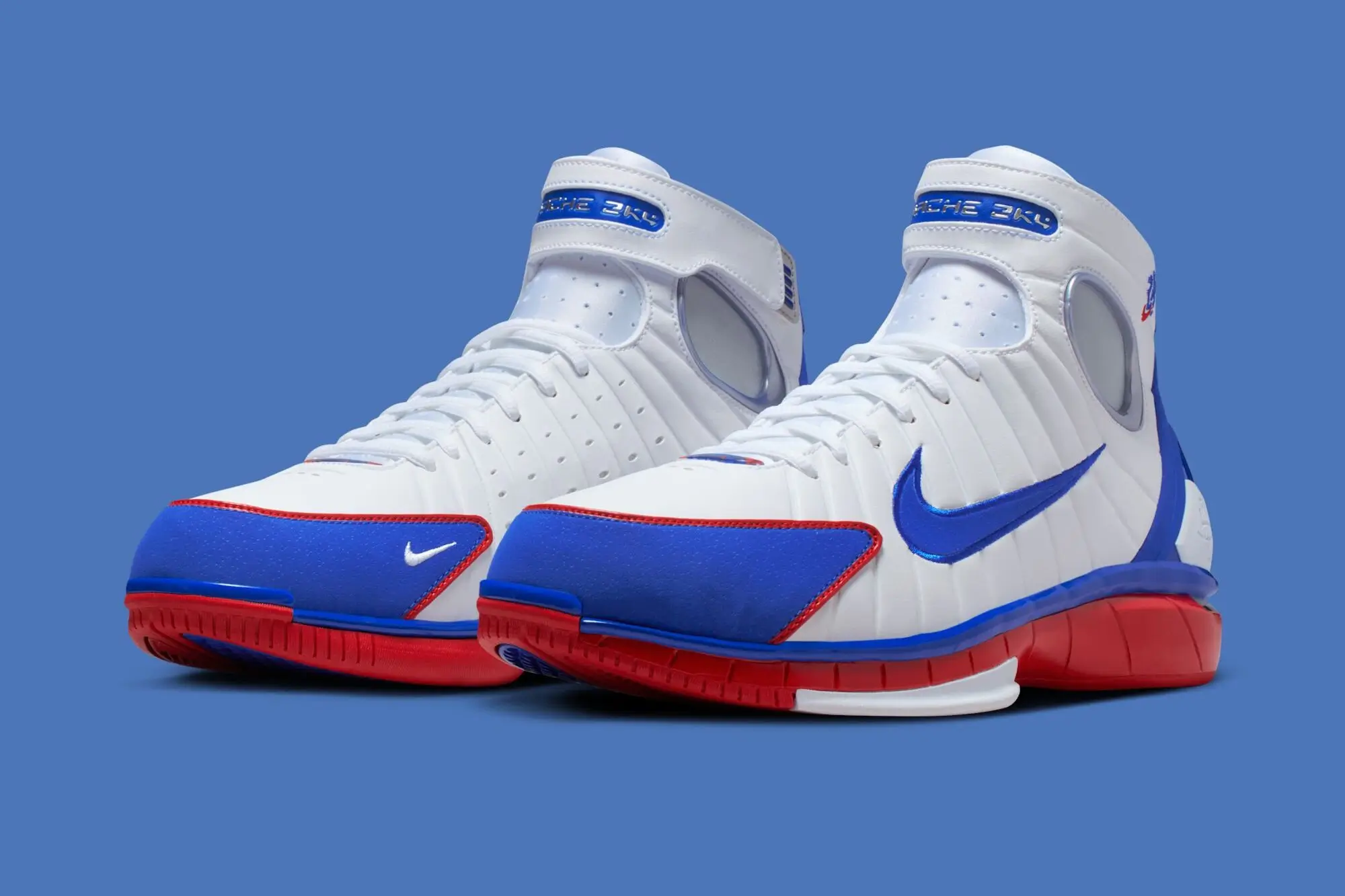 Nike Air Zoom Huarache 2K4 “All-Star” basketball shoes in white, blue, and red, shown in a studio product shot highlighting the high-top silhouette and retro performance design