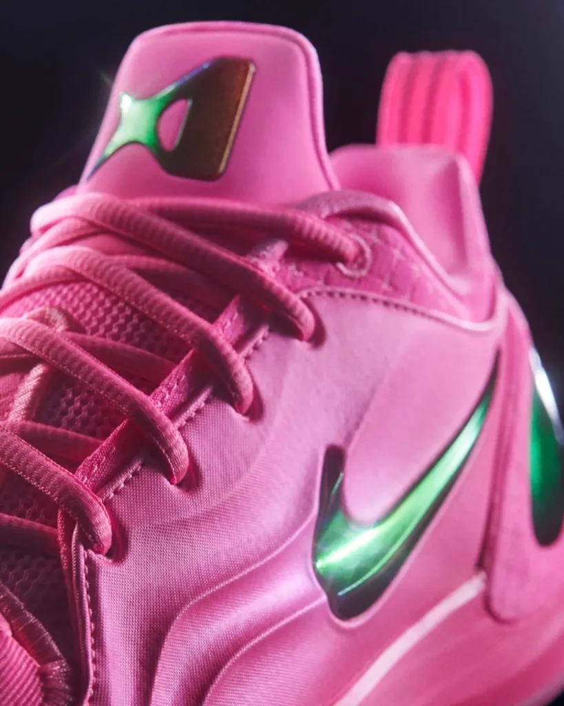 Close-up of the Nike A’Two in vibrant pink, featuring tonal laces, breathable mesh tongue, smooth synthetic upper, iridescent green Swoosh logo, and a sculpted heel tab with A’ja Wilson’s signature emblem