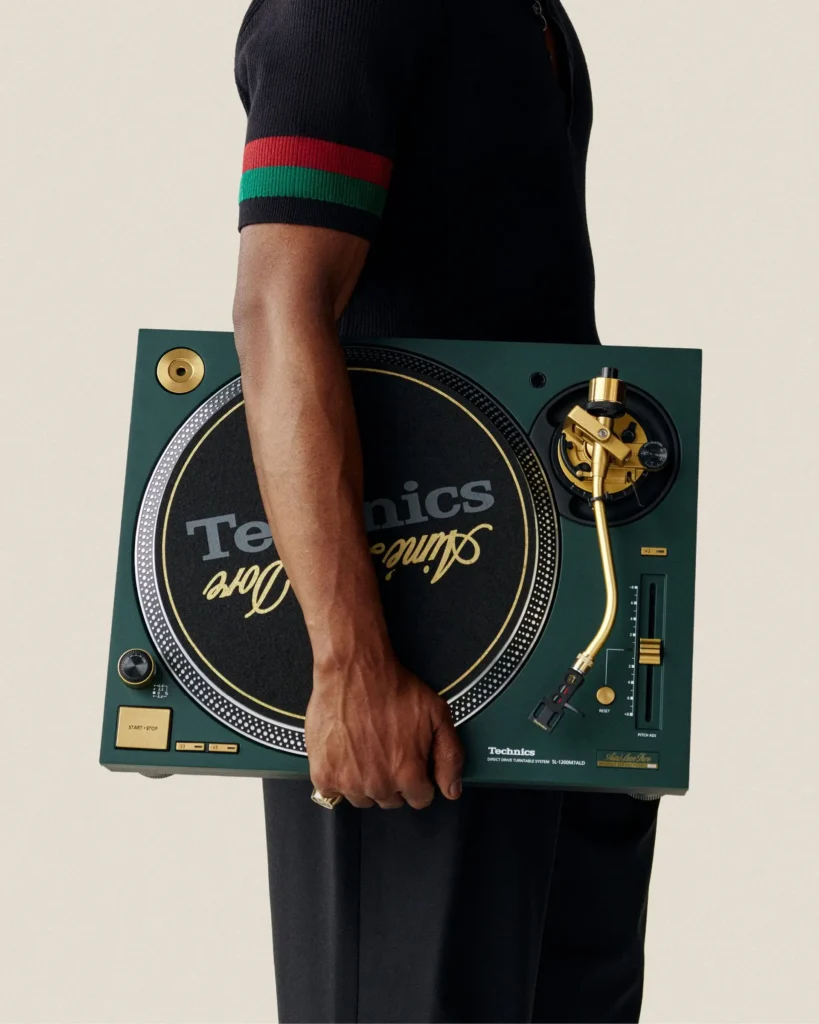 Model holding Aimé Leon Dore Technics turntable featuring premium materials and minimalist design