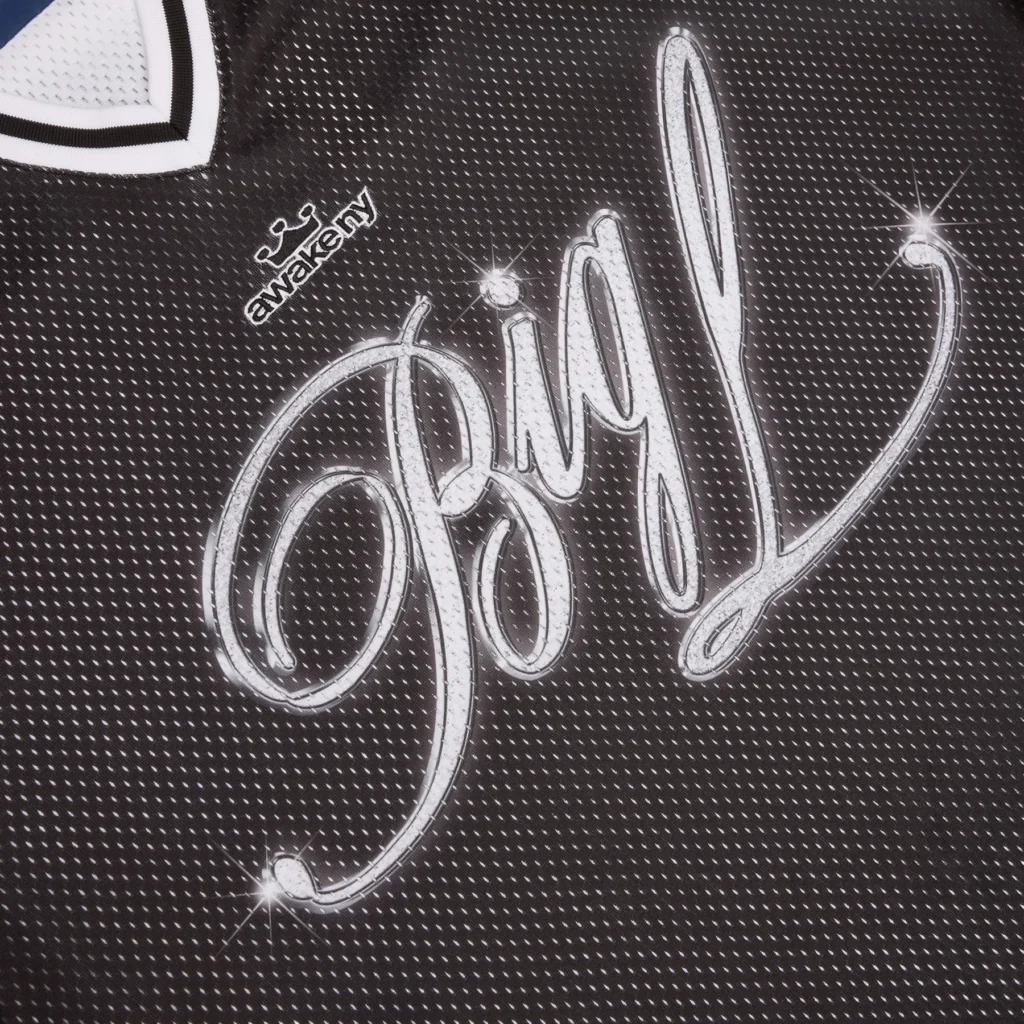Close-up of the Awake NY Big Picture Hockey Jersey chest graphic featuring large silver cursive “Big L” lettering on black mesh fabric