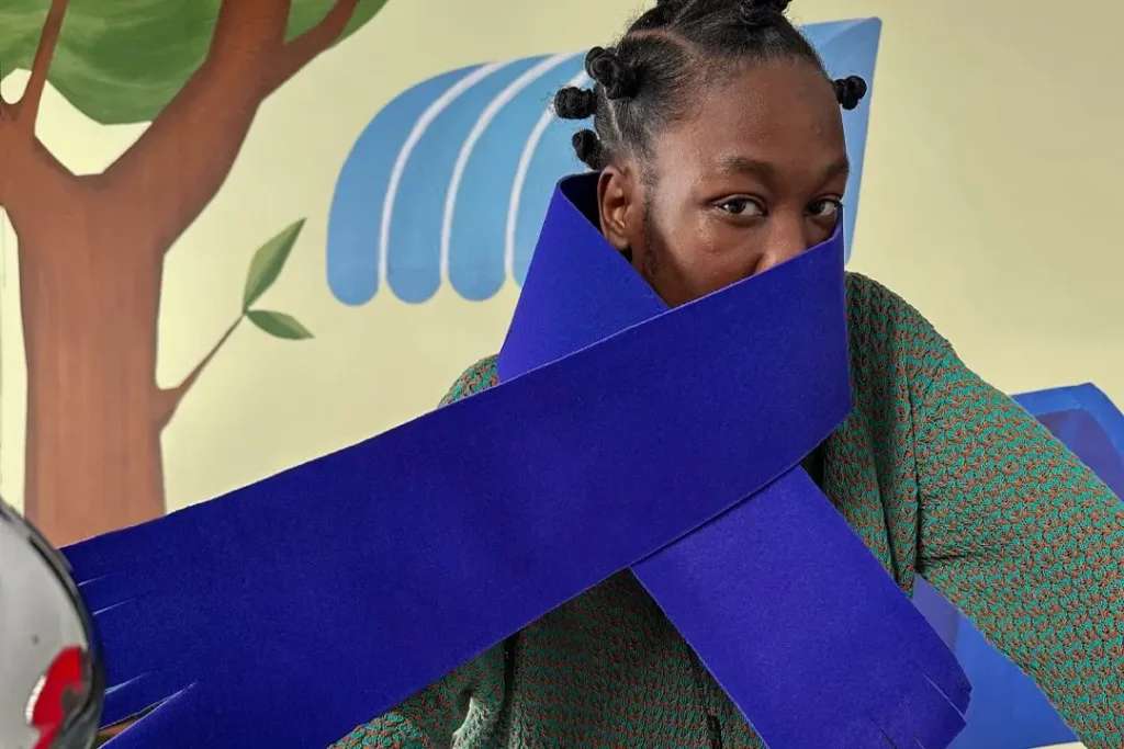 Model framed by bold purple ribbon sculpture in Axel Arigato Akaia campaign with Reggieknow