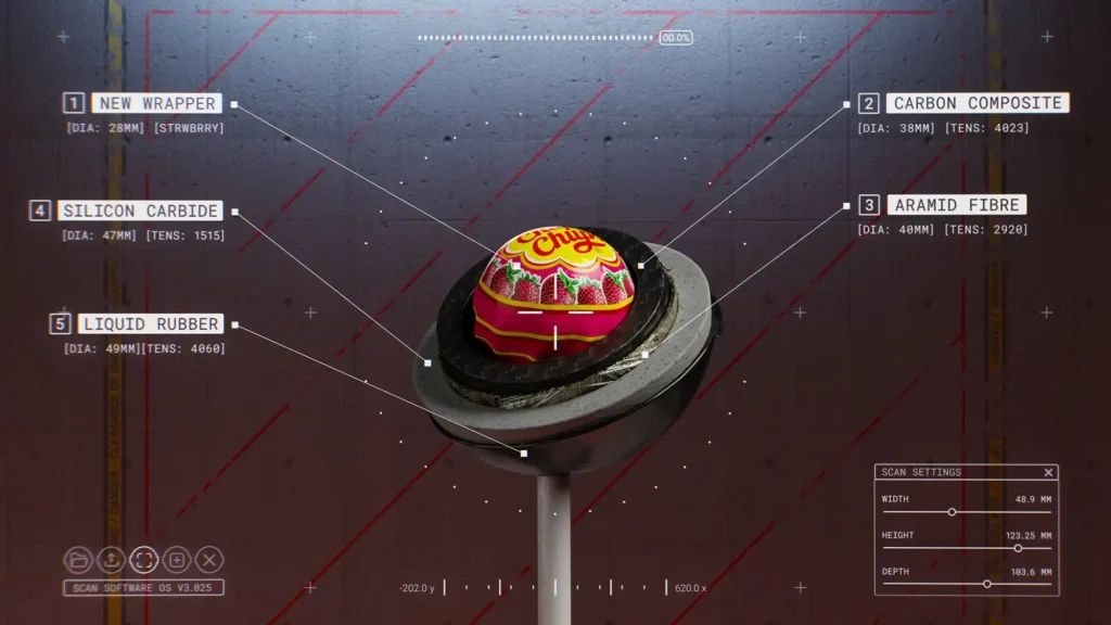 Close-up of a **Chupa Chups strawberry lollipop displayed in a futuristic scan-style interface, highlighting layered materials of the “Impossible” wrapper including carbon composite, aramid fibre, silicon carbide, and liquid rubber surrounding the candy