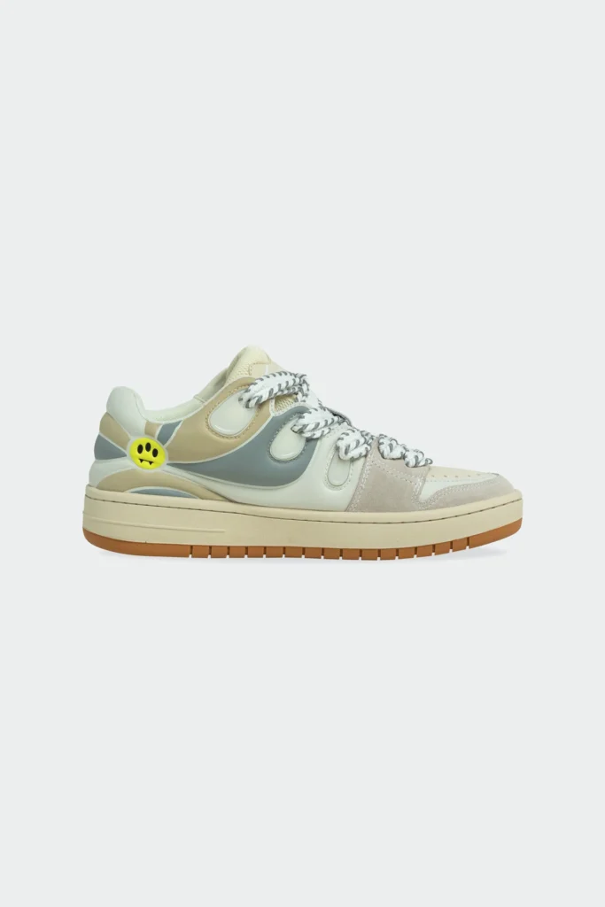 Lateral side view of Barrow OFF WHITE–TURTLEDOVE unisex skate sneaker featuring layered beige suede and smooth leather panels, grey overlays, chunky braided laces, gum sole, and signature yellow smiley face heel detail