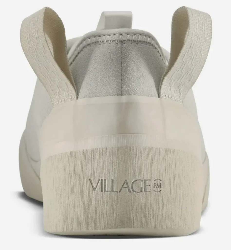 Rear view of cream Village PM 1PM shoes highlighting dual pull tabs, textured suede heel panel, and a sculpted off-white sole with subtle VILLAGE PM branding embossed at the back