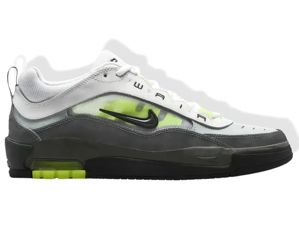 Side-profile view of a low-top Nike Air Max sneaker in grey, white, and black with neon green accents, featuring a layered upper, visible Air cushioning in the heel, and a clean studio background