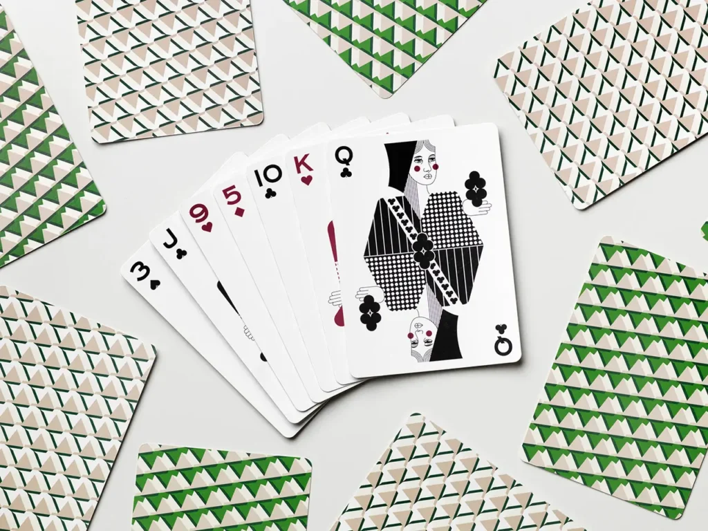 Spread of PRINTWORKS × Rosewood playing cards with geometric patterned backs and illustrated queen card