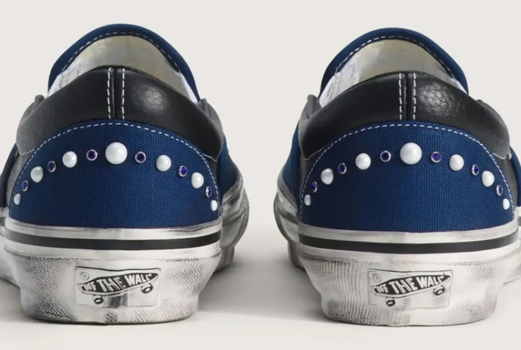 Rear view of Vans Pearlised Slip-On shoes in navy canvas with pearl and crystal embellishments and Off The Wall heel branding