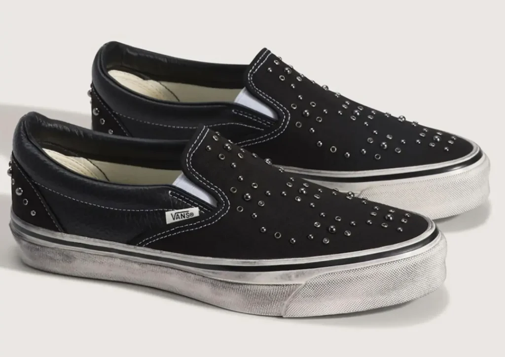 Black Vans Slip-On Pearlised edition featuring scattered metal studs across the canvas upper and textured leather heel panel