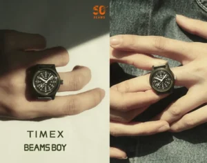 TIMEX BEAMS BOY ring watch worn on finger featuring black military-style dial and compact case with 50th anniversary branding