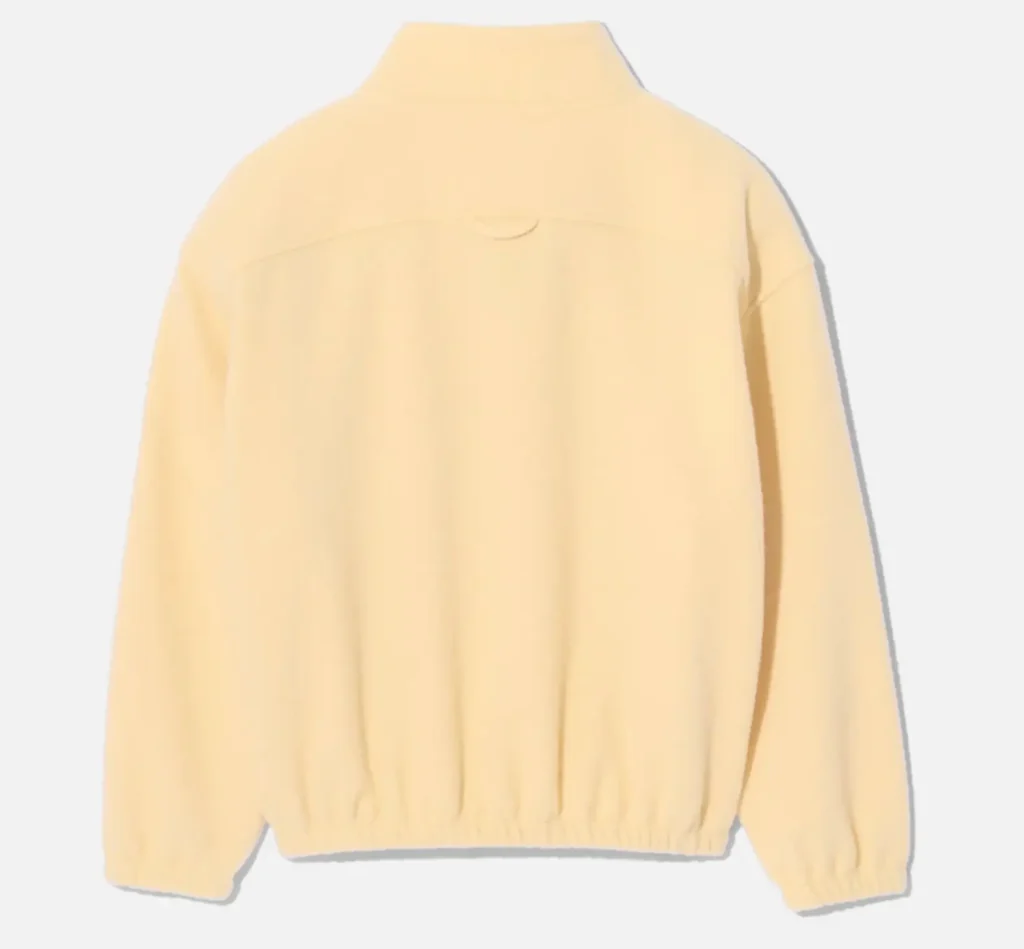 Back view of Rier natural wool fleece jacket in pale yellow, showcasing a clean minimalist design with a standing collar, soft biodegradable wool texture, and elasticated hem and cuffs for a relaxed structured fit