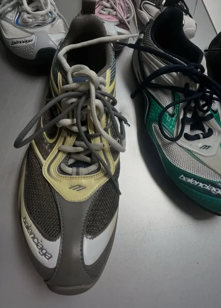 Balenciaga Radar shoes in multiple colorways featuring a streamlined low-profile silhouette, mesh uppers, and layered synthetic panels; foreground pair shows grey, cream, and pale yellow tones with double lacing system and debossed Balenciaga branding, while adjacent pair highlights white mesh with green overlays and black laces, emphasizing the shoe’s lightweight construction and adaptive fit design
